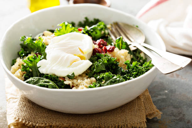 Healthy kale and quinoa salad Healthy raw kale and quinoa salad with poached egg on top poached food photos stock pictures, royalty-free photos & images