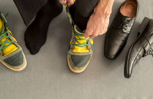 Healthy lifestyle balance concept. Businessman change shoes on sneakers. stock photo