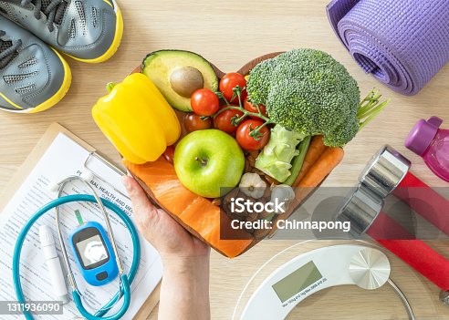 istock Healthy lifestyle on ketogenic diet, eating clean keto food good health dietary in heart dish with aerobic body exercise, gym workout training class , weight scale and sports shoes in fitness center 1311936090