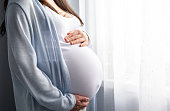 istock healthy pregnancy. Side view pregnant woman with big belly advanced pregnancy in hands. Banner copyspace for text. Elegant mother waiting baby 1323431279