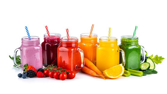 Collection of healthy fresh organic fruits and vegetables smoothies in Mason jars arranged in a row on white background. Fruits and vegetables included in the composition are strawberries, blueberries, beetroot, tomatoes, carrots, oranges, celery, cucumber and spinach. High resolution 42Mp studio digital capture taken with Sony A7rII and Sony FE 90mm f2.8 macro G OSS lens
