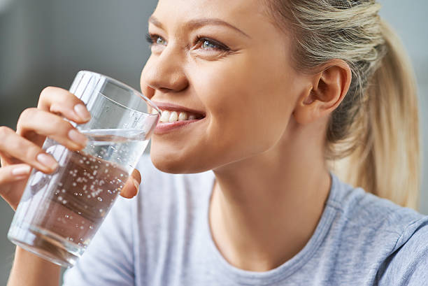 Healthy refreshment Beautiful young woman drinking water cold drink photos stock pictures, royalty-free photos & images