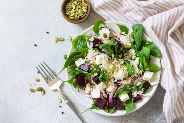 Healthy salad with couscous, soft cheese, beetroot and vinaigrette dressing. Top view flat lay background. stock photo