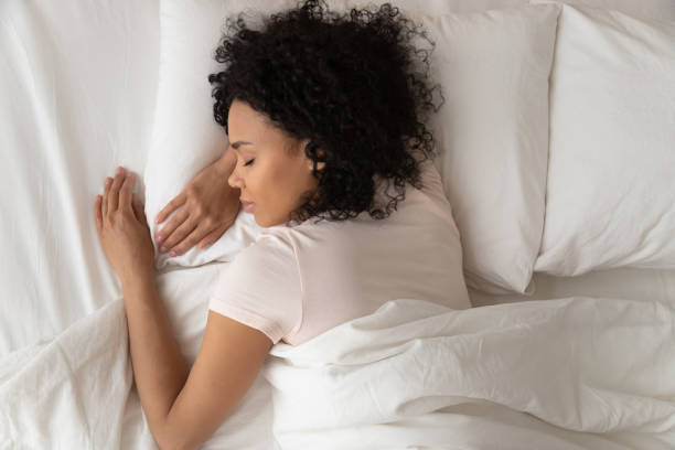 gezond serene afrikaans meisje slapen in comfortabel bed, top uitzicht - slaap stockfoto's en -beelden