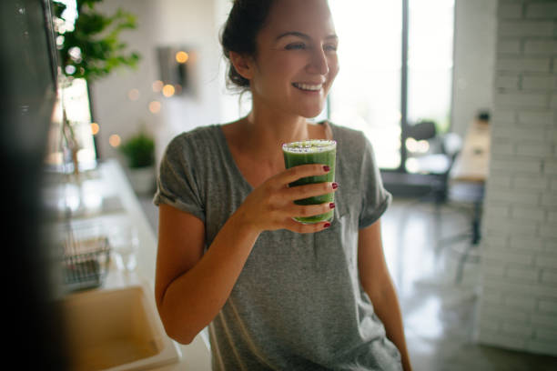 Healthy smoothie for breakfast Photo of a young smiling woman having healthy breakfast in the morning smoothie stock pictures, royalty-free photos & images