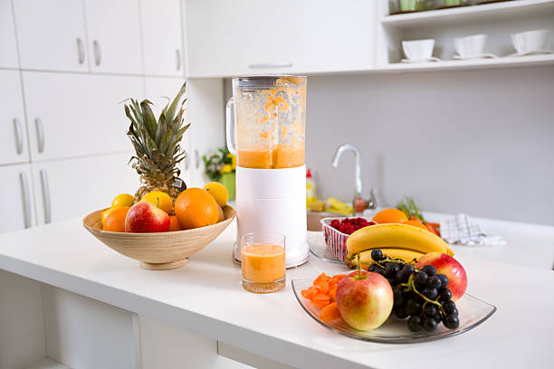healthy smoothie ingredients in blender with fresh fruit on kitchen...
