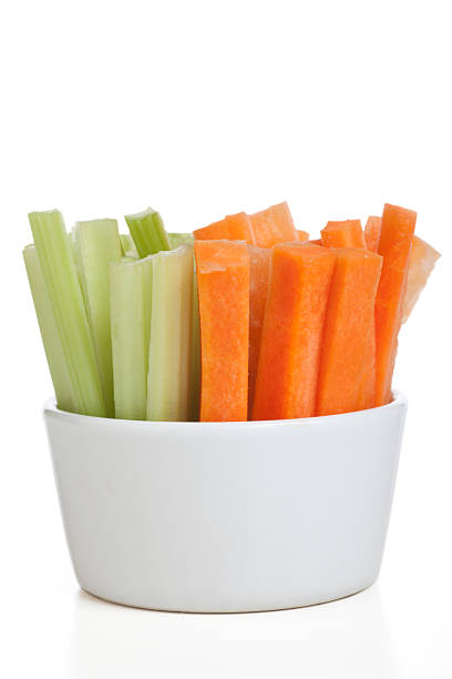 Healthy Snack Bowl of carrot and celery sticks isolated on a white background. celery stock pictures, royalty-free photos & images