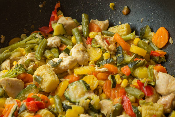 Healthy stir-fried vegetables and chicken in the pan stock photo
