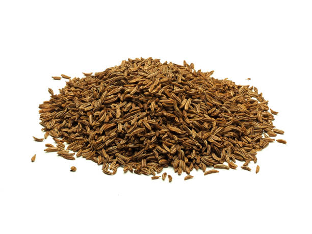 A heap of caraway seeds on white background stock photo