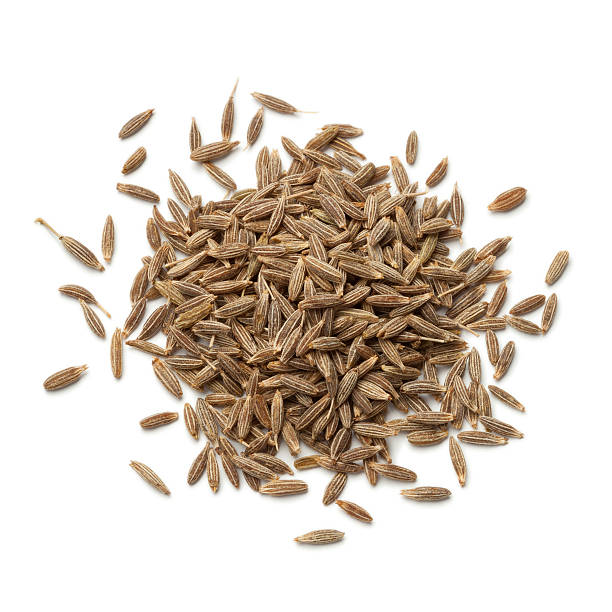 Heap of dried cumin seeds stock photo