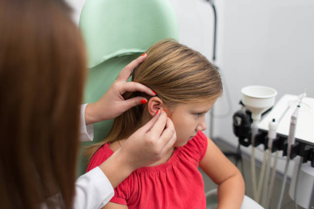 hearing aid checkup in otolaryngologist's office stock photo