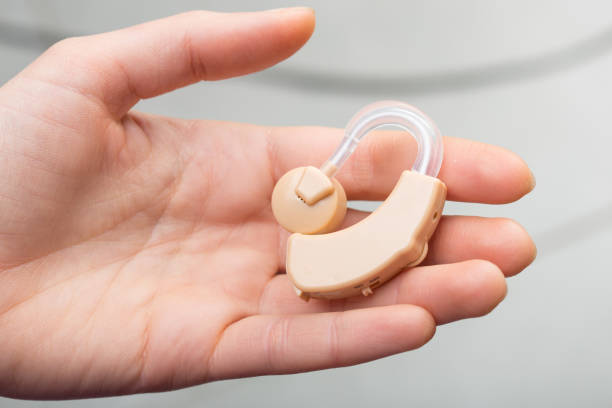 hearing aid close-up in a hand - hearing aids stok fotoğraflar ve resimler