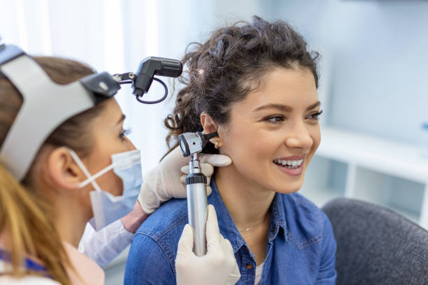 Hearing exam for a woman. Diagnosis of impairment and hearing testing in adults. Patient woman during an ear check-up with an audiologist stock photo