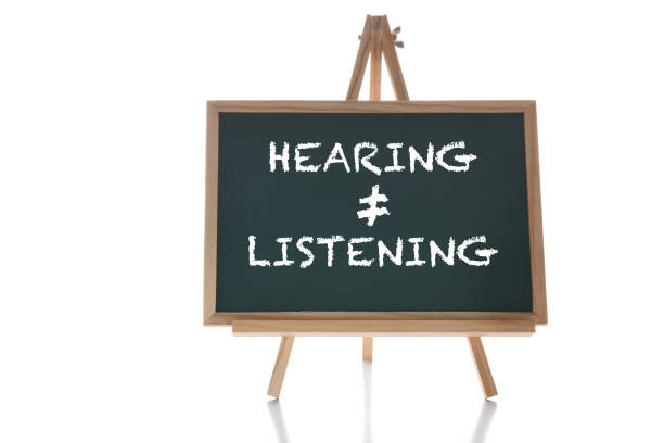 Hearing not equal listening written on chalkboard on white background stock photo
