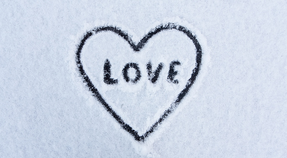 Heart and word Love written on the snow for the Valentines Day. Valentines Day concept. Banner.