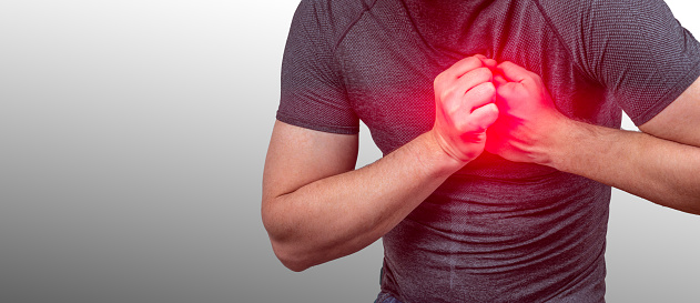 heart attack. Severe heartache, man suffering from chest pain, having heart attack or painful cramps, pressing on chest with painful. Man clutching his chest from acute pain. Heart attack symptom