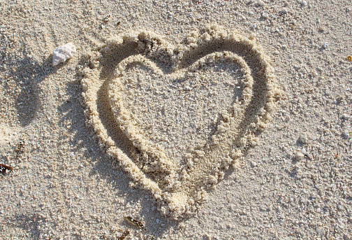Heart drawn on the sand. bright sunny photo.