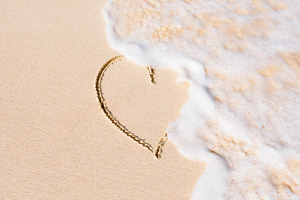 Heart on sand beach being washed away Heart on sand being washed away by waves. divorce beach stock pictures, royalty-free photos & images