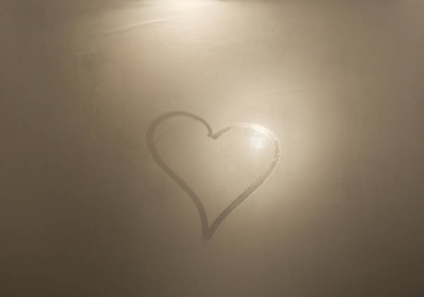heart on steamed mirror stock photo