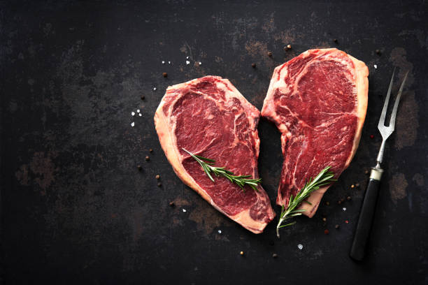 Heart shape raw dry aged beef rib steaks (cote de boeuf) stock photo