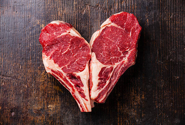 Heart shape Raw steak on bone stock photo