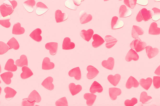 hearts shape confetti on pink pastel holiday background. - carnival accessories flat lay imagens e fotografias de stock