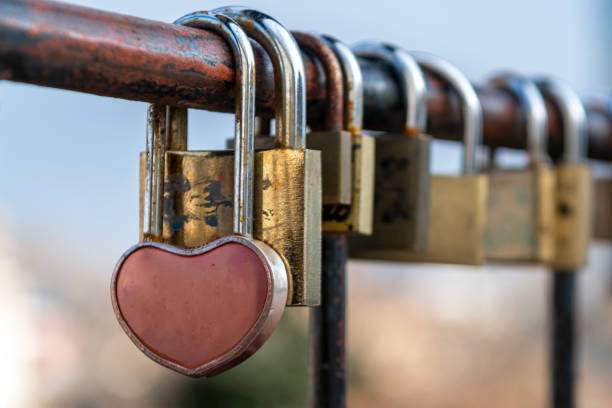 a heart-shaped lock locked on the fence - tadic stockfoto's en -beelden