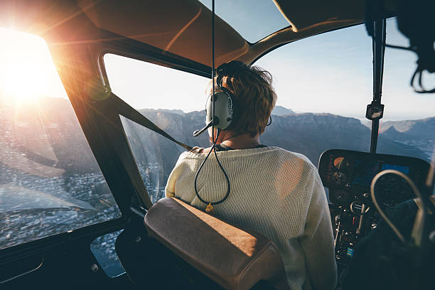 Helicopter passenger admiring the view Rear view of female tourist on helicopter looking out of the window. Helicopter passenger admiring the view. helicopter stock pictures, royalty-free photos & images