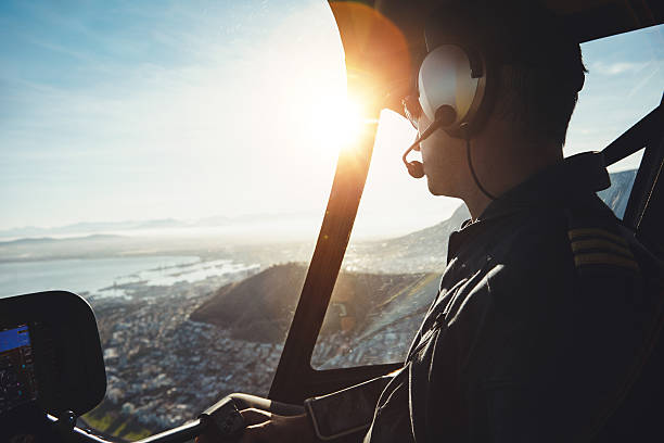 Helicopter pilot flying aircraft over a city Close up of a helicopter pilot flying aircraft over a city on a sunny day pilot stock pictures, royalty-free photos & images