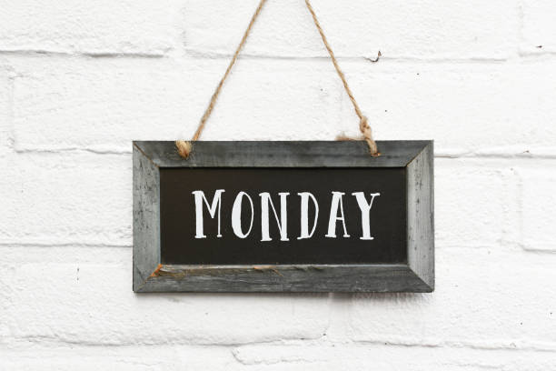Hello monday motivation for a new week text on hanging board white brick outdoor wall stock photo