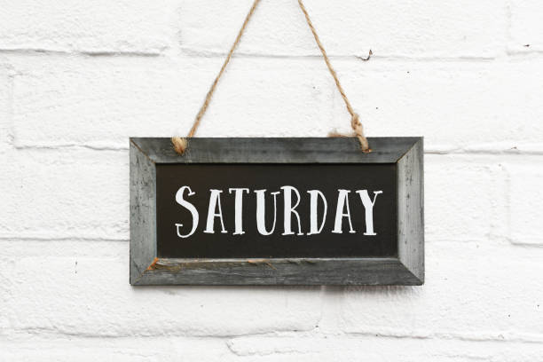 Hello Saturday finally weekend text on chalkboard Hello saturday text on hanging board white brick outdoor wall weekend activities stock pictures, royalty-free photos & images