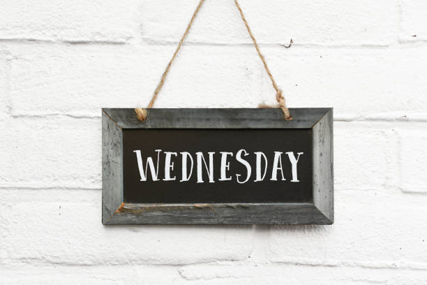 Hello wednesday quote on sign text board against white brick outdoor wall stock photo