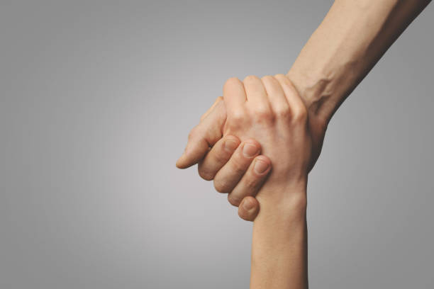 help friend through a tough time. rescue gesture. support, friendship and salvation concept. holding hands stock photo