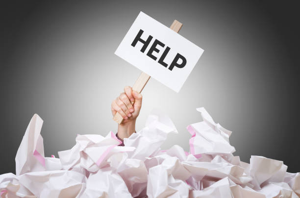 Help placard Help placard in hand with crumpled paper pile. buried stock pictures, royalty-free photos & images