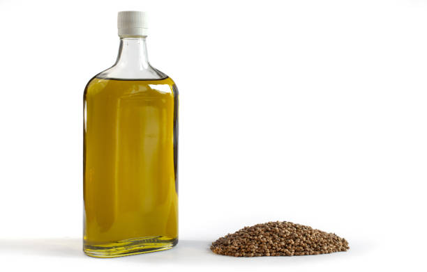 Hemp oil in a bottle with a bunch of cannabis seeds. stock photo