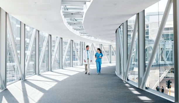 Her knowledge is impressing Shot of two healthcare workers walking together corridor stock pictures, royalty-free photos & images