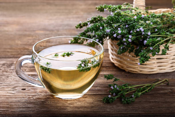 Herbal tea with thyme over rustic wooden background. Healthy drink. stock photo