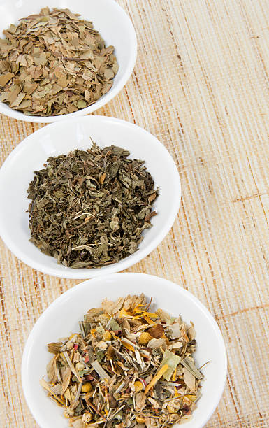 Herbal teas in small white bowls on natural matting stock photo