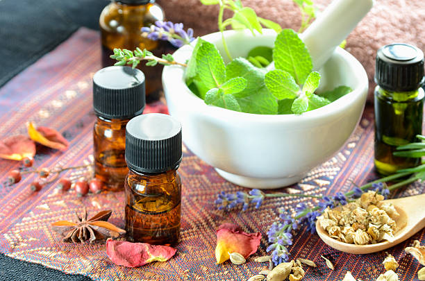 herbs and essential oils with mortar and pestle stock photo