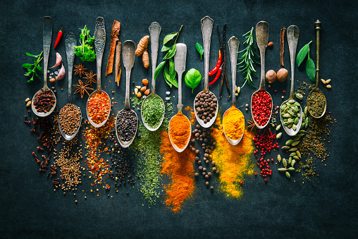 Colourful various herbs and spices for cooking on dark background