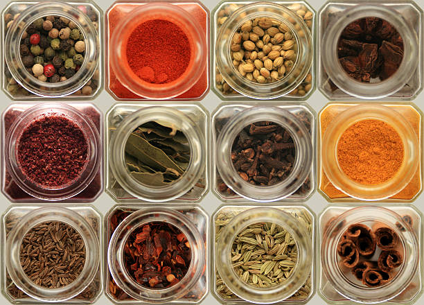 herbs and spices in glass jars stock photo