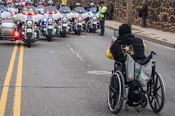 Here Comes the Parade Washington, DC - January 16, 2017: Man in wheelchair snaps photo during the Martin Luther King, Jr. Day Peace Walk abnd Parade. martin luther king jr day stock pictures, royalty-free photos & images