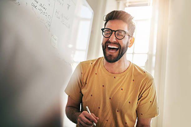He's the one that brings humour to the team Cropped shot of a team of designers brainstorming together in an office laughing stock pictures, royalty-free photos & images