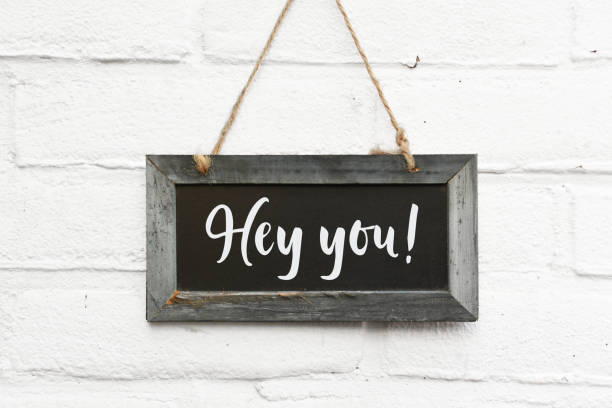 Hey you welcome text on hanging sign board welcome text stock photo