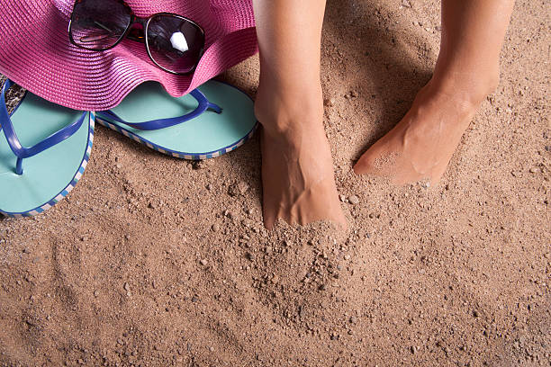 hiding toes in the sand - voeten in het zand stockfoto's en -beelden