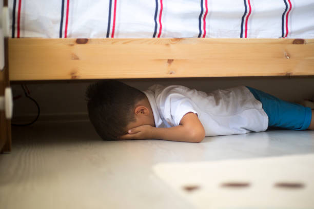 Hiding under a bed  violence of children stock pictures, royalty-free photos & images