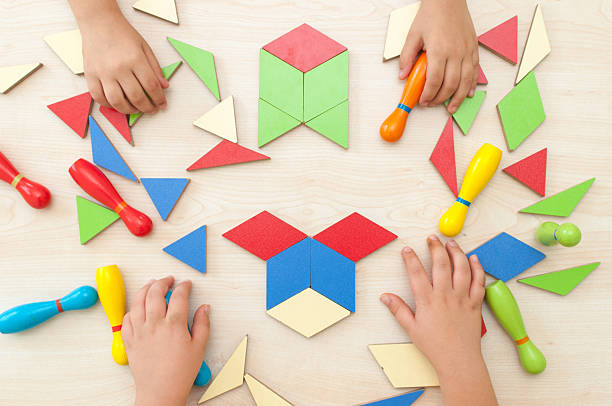 vista de alto ángulo de una niños jugando tangrama rompecabezas - tangram casa fotografías e imágenes de stock