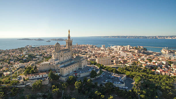 High angle view of cityscape by sea against sky High angle view of cityscape by sea. Notre Dame de la Garde in Marseille against clear sky. Buildings by seascape on sunny day. cathedral photos stock pictures, royalty-free photos & images