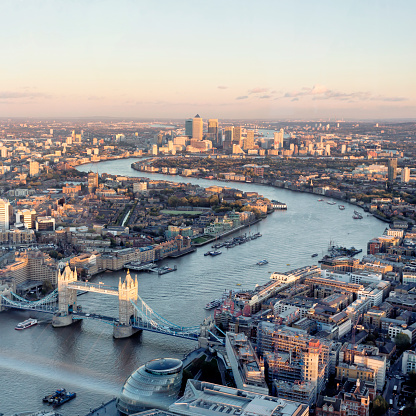 London aerial cityscape with landmarks including the Thames, Canary Wharf, Tower Bridge and City Hall.