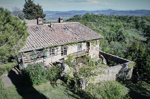High angle view of old abandoned farmhouse and green landscape against sky during sunny day
